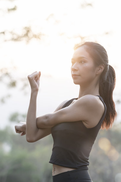 年轻漂亮的女人在户外做晨练的肖像。图片下载