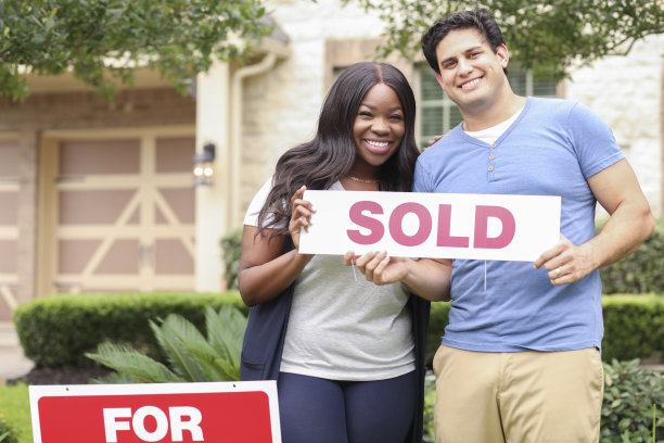 兴奋的年轻夫妇购买了他们的第一套房子。图片下载