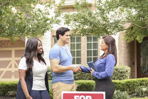 房地产经纪人和年轻夫妇买房。图片下载