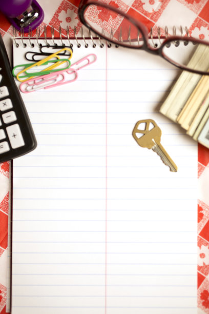 厨房桌子上有记事本，计算器，现金，眼镜，回形针和订书机。计算再融资决策。图片下载