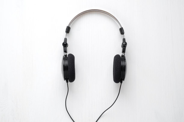 白色木质背景的老式有线耳机。音乐海报模板。图片下载