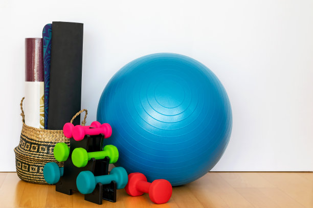 由健身哑铃、垫子、地板上的大健身球组成。适合在家健身的运动配件。运动放松，健康理念。图片下载