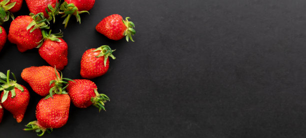 成熟的草莓在黑色背景，夏季浆果，俯视图图片下载