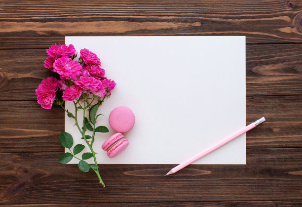 红玫瑰，铅笔和空白纸卡在木制背景。复制空间，平铺，图片下载