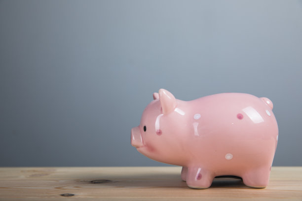 小猪储蓄罐放在木桌上图片下载