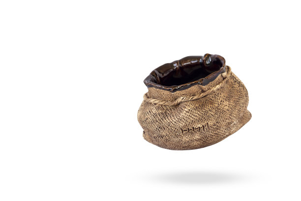 白色背景上的陶瓷容器。棕色的袋子。图片下载