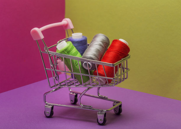 带轮子的购物篮。在线轴上缝线。图片下载