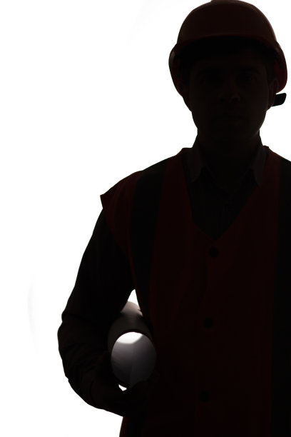 剪影的工程师工人，工头站在安全帽上与建筑工程卷隔绝背景，男性职业观念图片下载