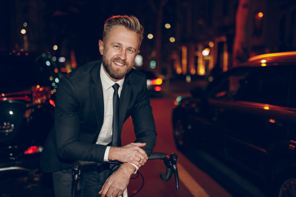 快乐的商人在时尚的西装站在附近的自行车在城市图片下载