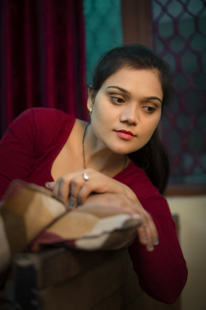 一幅美丽安详的印度年轻女子躺在床上沉思的画像。图片下载