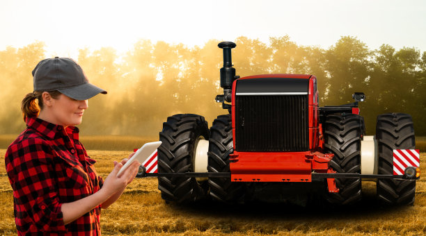 一位农民用数字平板电脑控制着一台自动拖拉机图片下载
