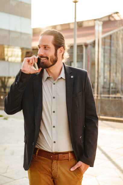 图片内容公司的人或办公室经理在西装微笑，而步行附近的商业中心和讲手机图片下载