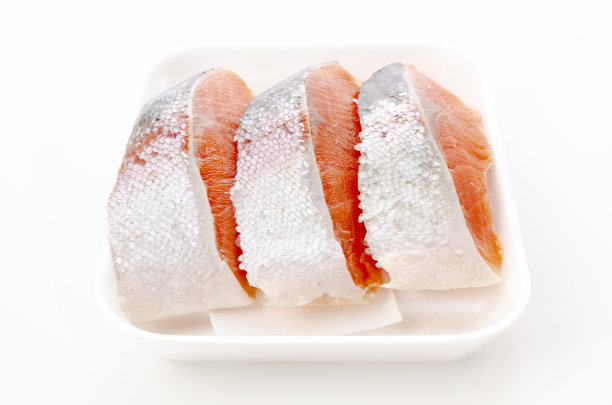 在白色背景上的泡沫盘里的生鲑鱼片图片下载