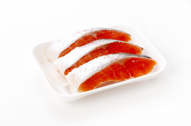 在白色背景上的泡沫盘里的生鲑鱼片图片下载