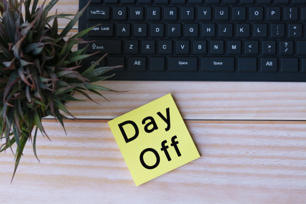 黄色笔记上的文字与键盘和盆栽植物在木桌上。天假图片下载