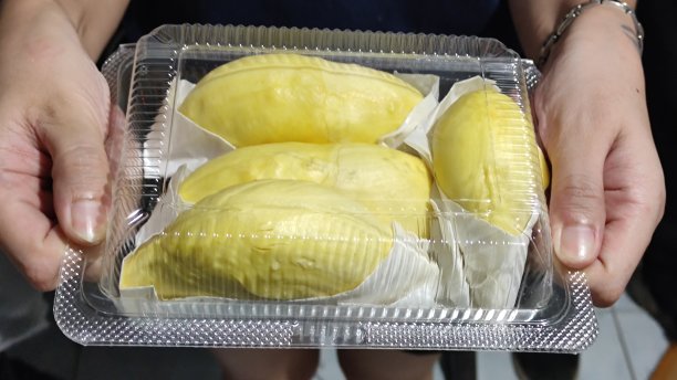 榴莲用纸包在一个透明的塑料盒子里。图片下载