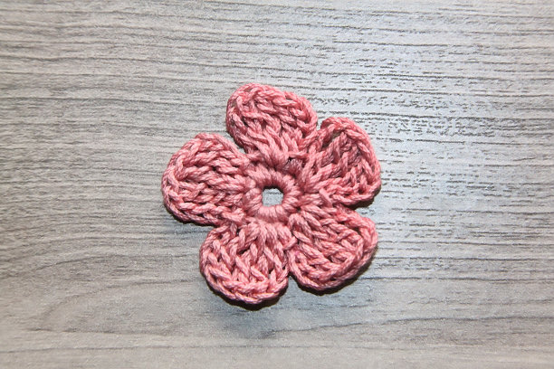 俯视图上的三个手织花边餐巾，棉线球，钩针钩和一个花瓶与三色堇花在木桌上。平铺，拷贝空间图片下载