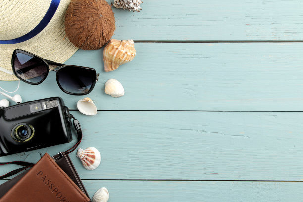 旅行概念相机，护照，眼镜。蓝色的木桌上放着帽子和贝壳。放松。假期。前视图。免费的地方。图片下载