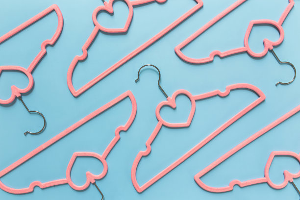 黑色星期五或服装行业概念的蓝色背景和粉红色衣架图片下载