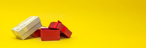 礼品盒上的黄色背景，横幅。红色的礼品盒，打开的盒子。印刷的明信片，带有文字位置的横幅。全景照片，大尺寸，空白空间祝贺或设计图片下载