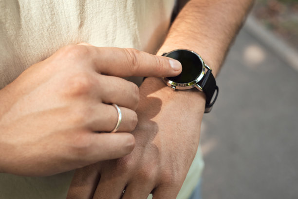 一个男人的手的近距离智能手表。积极的生活方式。时间管理，机动性，社会和技术概念。一个男人看他时髦的手表上的时间图片下载