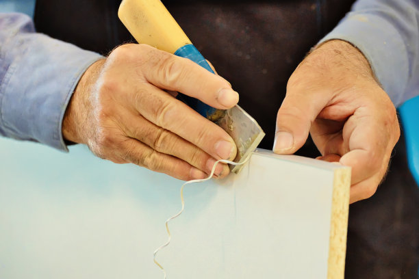 一位上了年纪的木匠的手和工具，而工作的特写镜头图片下载