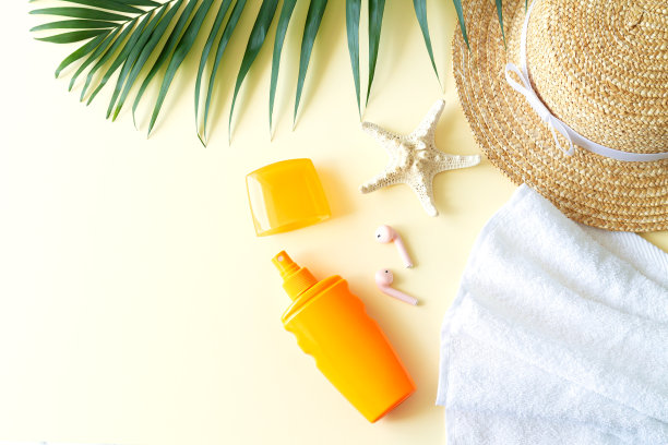 夏季女性海滩配件俯视图:帽子，防晒霜，棕榈叶，海星，毛巾和耳机图片下载