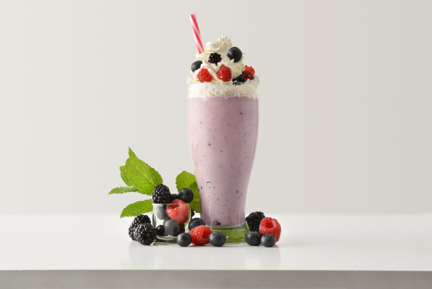 草莓奶昔与奶油装饰与水果在桌上孤立图片下载