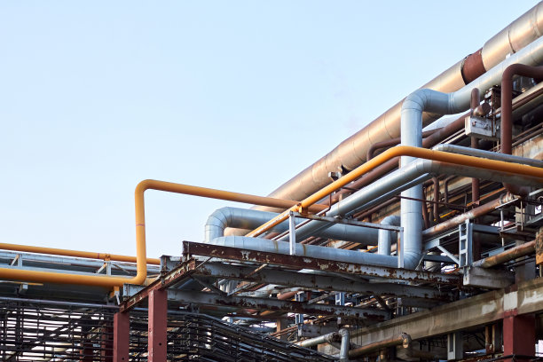 成堆的电力电缆和钢管与气体、氧气空气覆盖着锈蚀和老化的痕迹。石化行业通信概念的复杂性。背景与copyspace图片下载