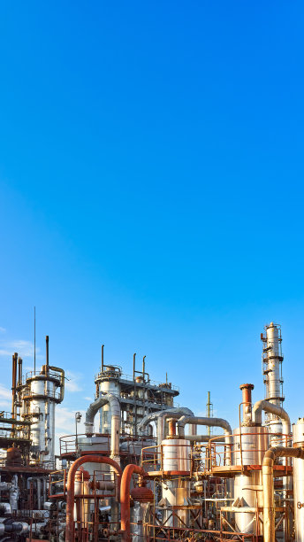 老蒸馏塔和反应器在蓝色的黄昏日落天空背景下化工厂。外部银色金属锈企业16x9垂直与copyspace。图片下载