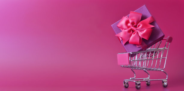 购物车与礼盒隔离在紫色背景。图片下载