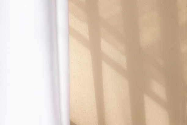 晨光透过玻璃窗照在米黄色的墙壁上。图片下载