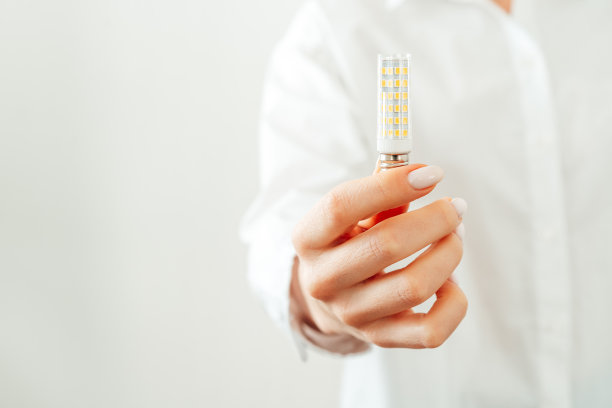 穿白衬衫的女人手里拿着灯泡图片下载