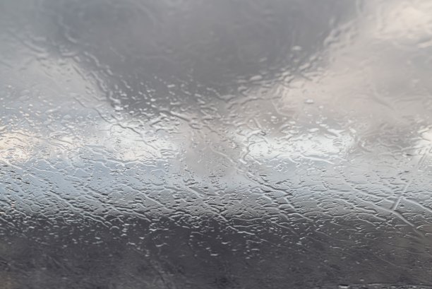 雨水湿透了挡风玻璃。还有大海，云彩和天空图片下载