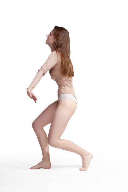 年轻修长的女孩，留着长发，穿着米色的紧身衣，在白色背景的画室里图片下载