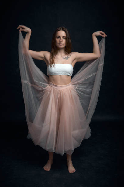 年轻的女孩穿着白色上衣和桃裙跳舞图片下载
