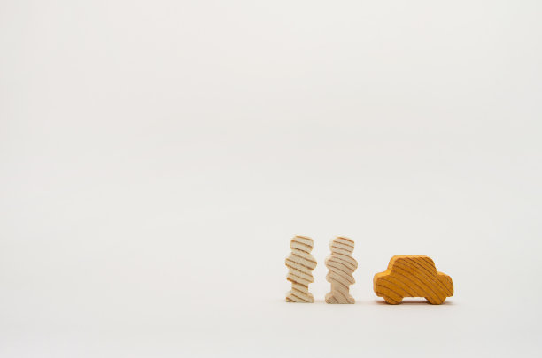 木雕人物站在一辆木制汽车旁。业务概念。由天然材料制成的汽车。生态友好的图片下载