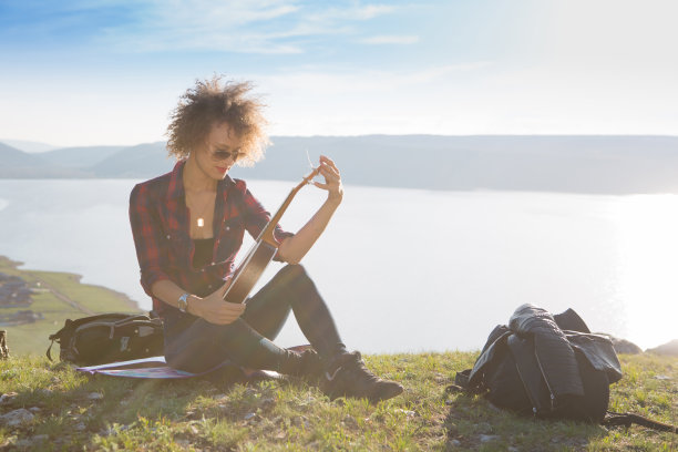 女人带着吉他尤克里里在山中，令人惊叹的风景，令人惊叹的美丽的自然，山脉，日落图片下载