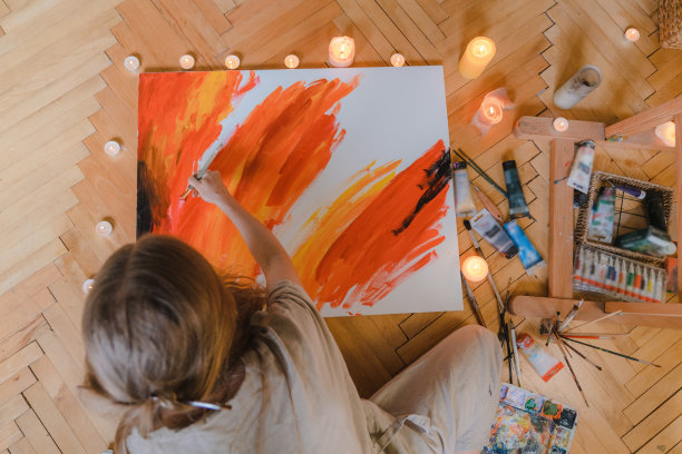 一个女人在她公寓的地板上画画图片下载