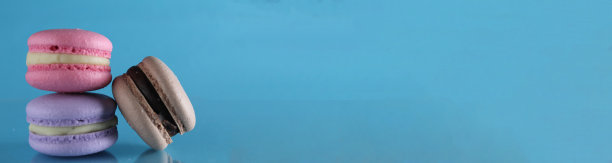 三个杏仁饼干放在一个三角形的蓝色背景上，放置文本和拷贝空间图片下载