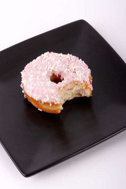 被咬了一口的粉色糖霜甜甜圈图片下载