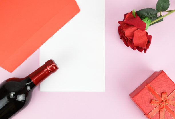 一张白纸上写着一瓶红酒。旁边有一个信封，一朵红玫瑰和一个礼品盒图片下载