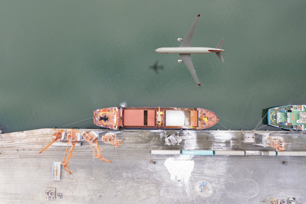 飞机在货船上空飞行。图片下载