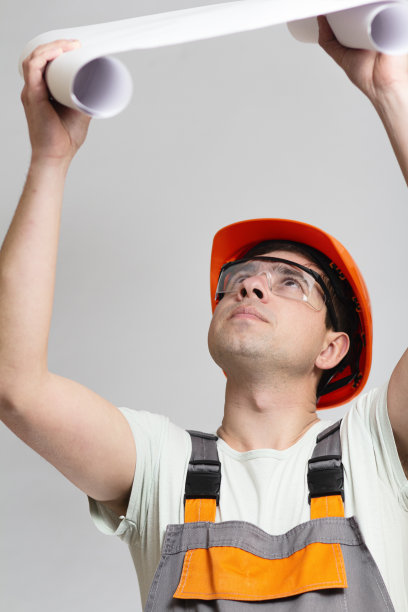 身着制服的人在灰色工作室的背景下兴致勃勃地打开了论文项目。有趣的建筑工人图片下载