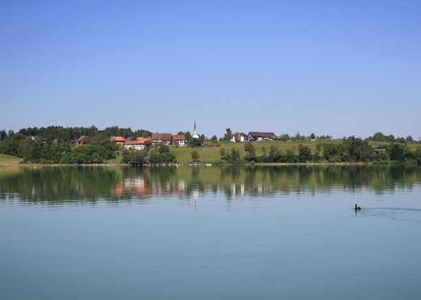田园风光反映在普法菲肯湖，普法菲肯。古老的村庄Seegraben, Seegraeben。瑞士苏黎世，一个平静的春天早晨。图片下载