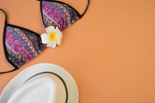 短裤，太阳镜，泳衣，鸡蛋花，夏季度假概念。橙色背景上的夏季娱乐配件。布局图片下载