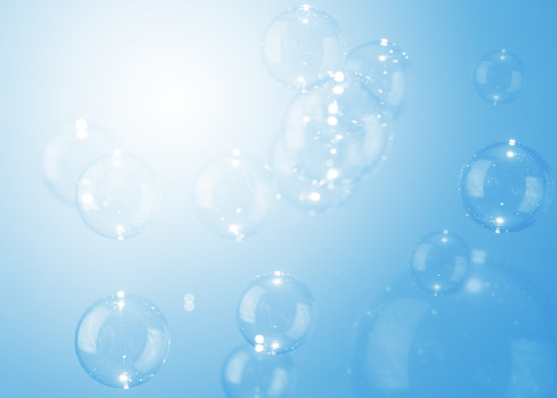 美丽透明的肥皂泡漂浮在蓝色背景。图片下载
