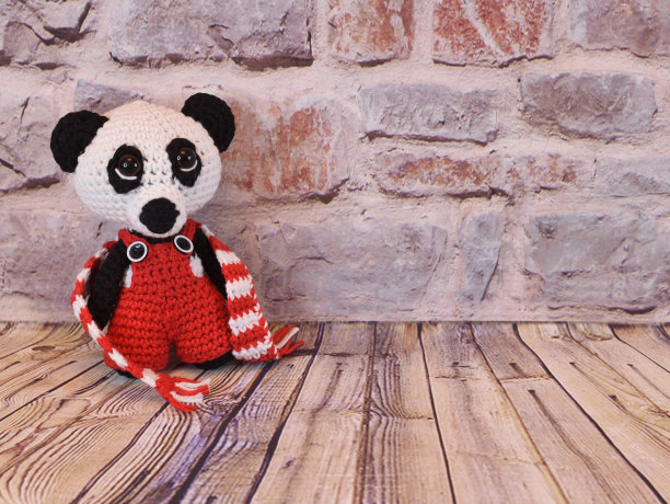 在一堵砖墙上用解开的围巾编织着熊猫图片下载