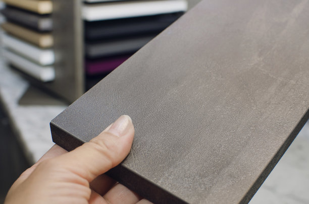 设计师拿着一个带有混凝土纹理的刨花板样品，特写。图片下载