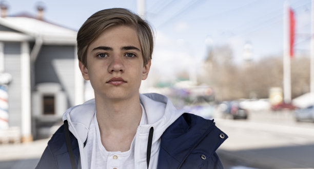 严肃的少年学生在街上走着图片下载